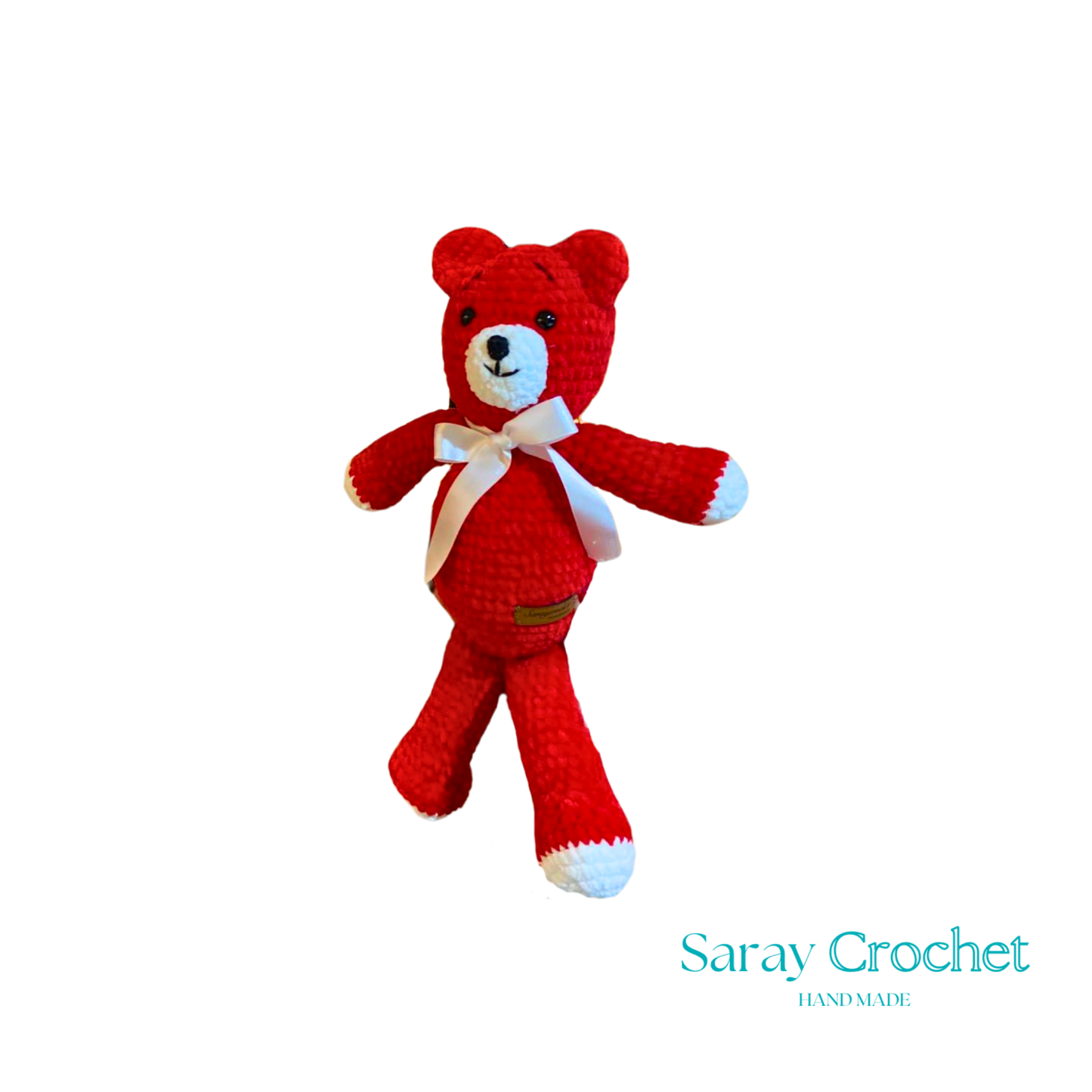 A red plush toy in the shape of a bear with a white bow ribbon around its neck.