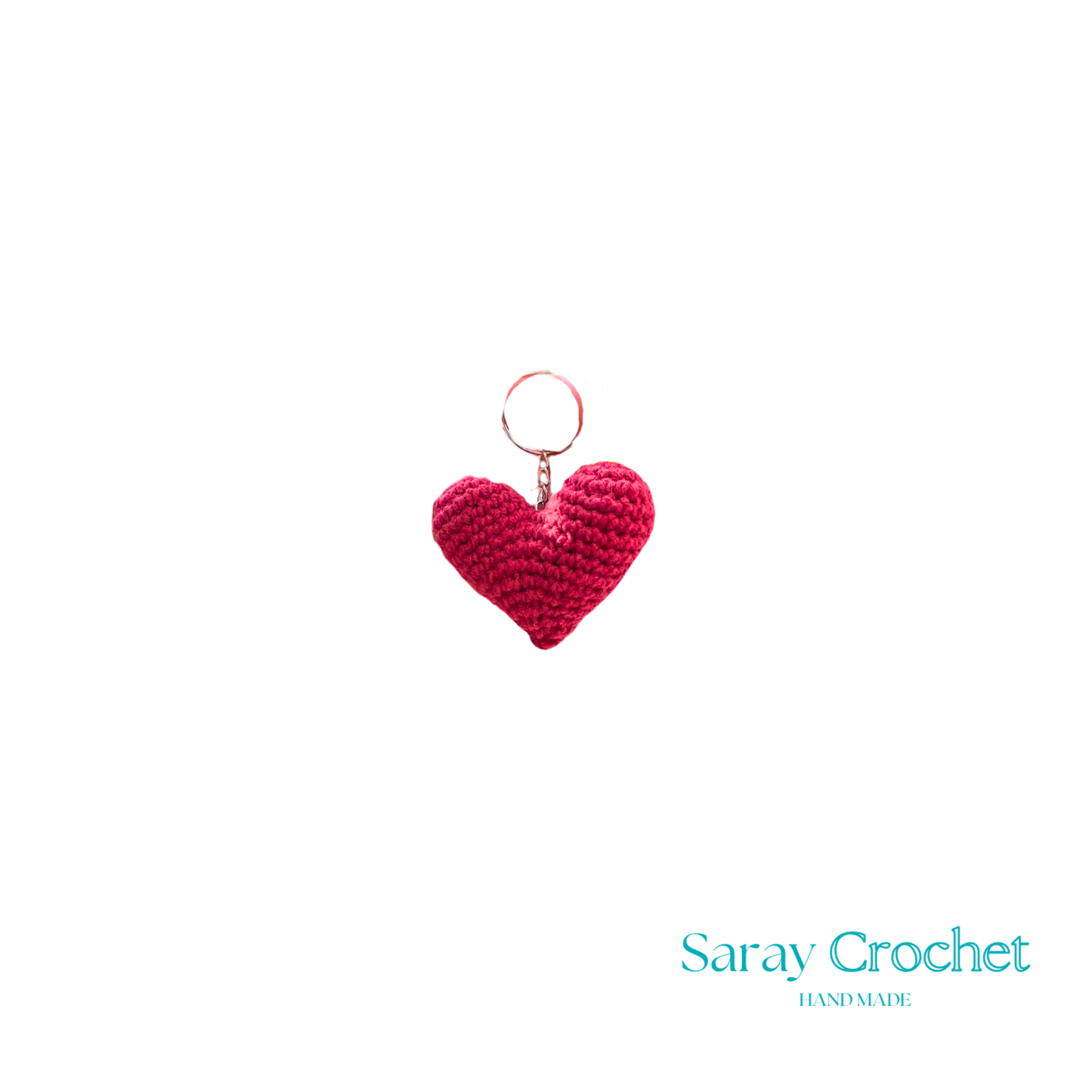 A red heart-shaped pendant with a design resembling a face, possibly a stylized representation of a person or an abstract design.