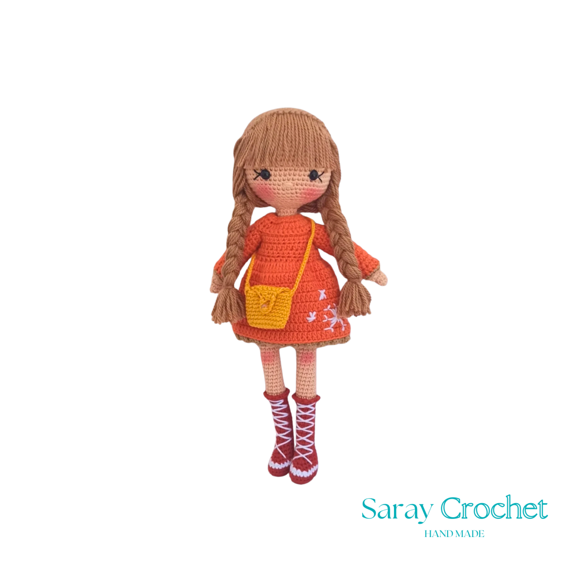 Handmade crocheted doll with orange winter coat and scarf, beige boots, and brown hair.