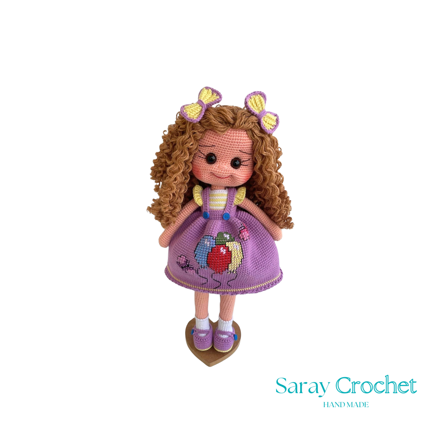 Handmade doll with curly brown hair and a purple dress with balloon print, complete with a bow and lace details.