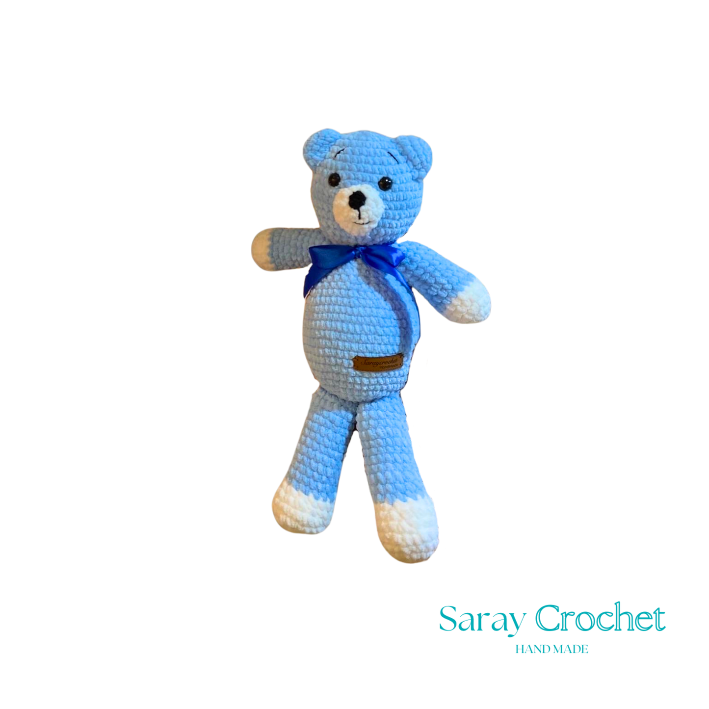 Blue crocheted teddy bear with a blue bow tie on a white background, branded 'Saray Crochet'.