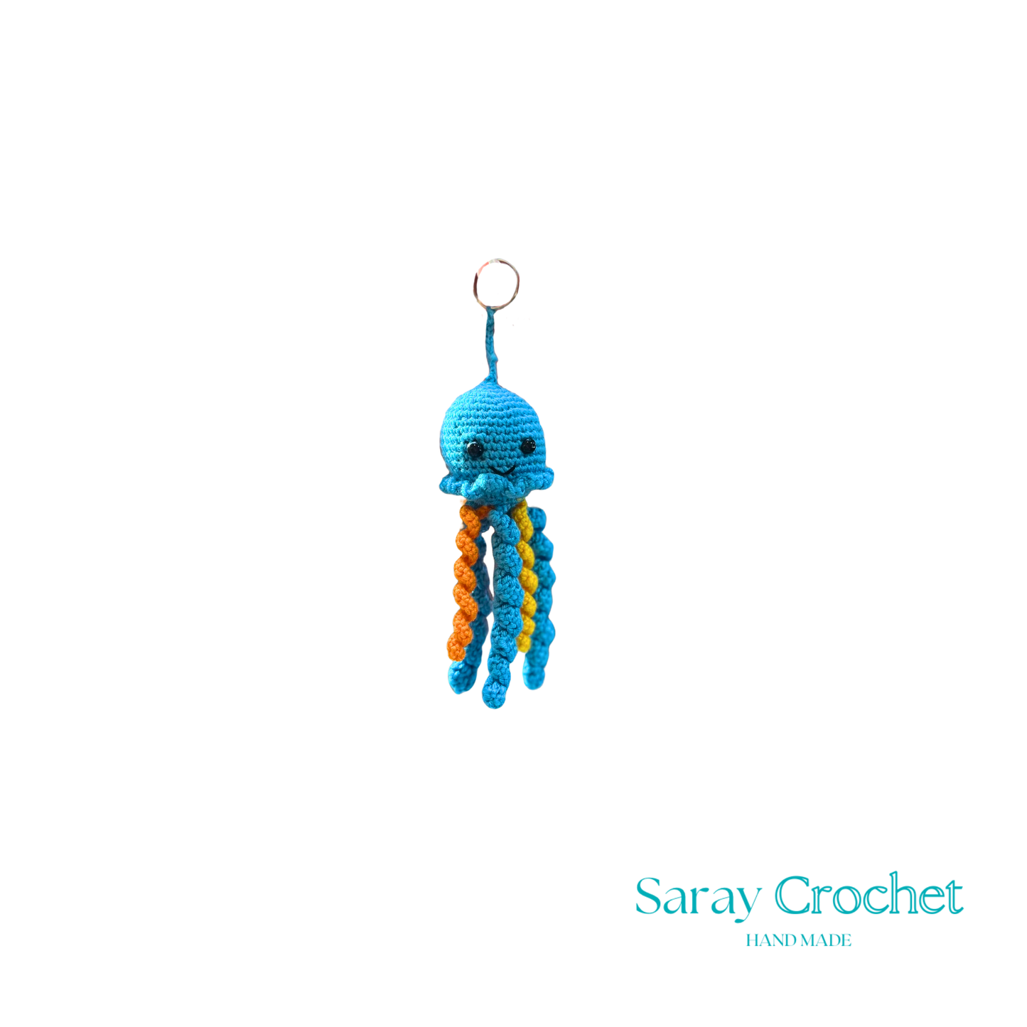 Crocheted octopus keychain with blue body and orange tentacles on a white background, branded 'Saray Crochet'.