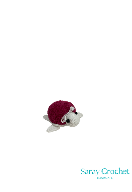 Crocheted turtle with red shell on a white background, branded 'Saray Crochet'.