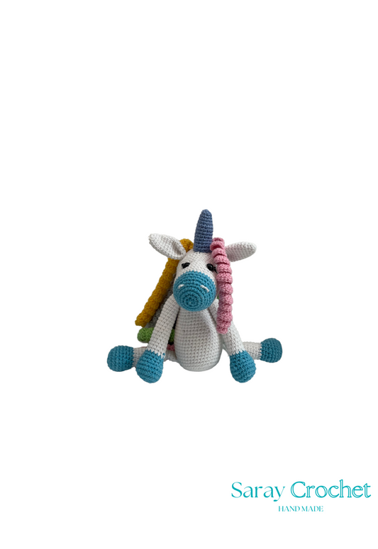 Crocheted unicorn toy with colorful mane on a white background, branded 'Saray Crochet'.