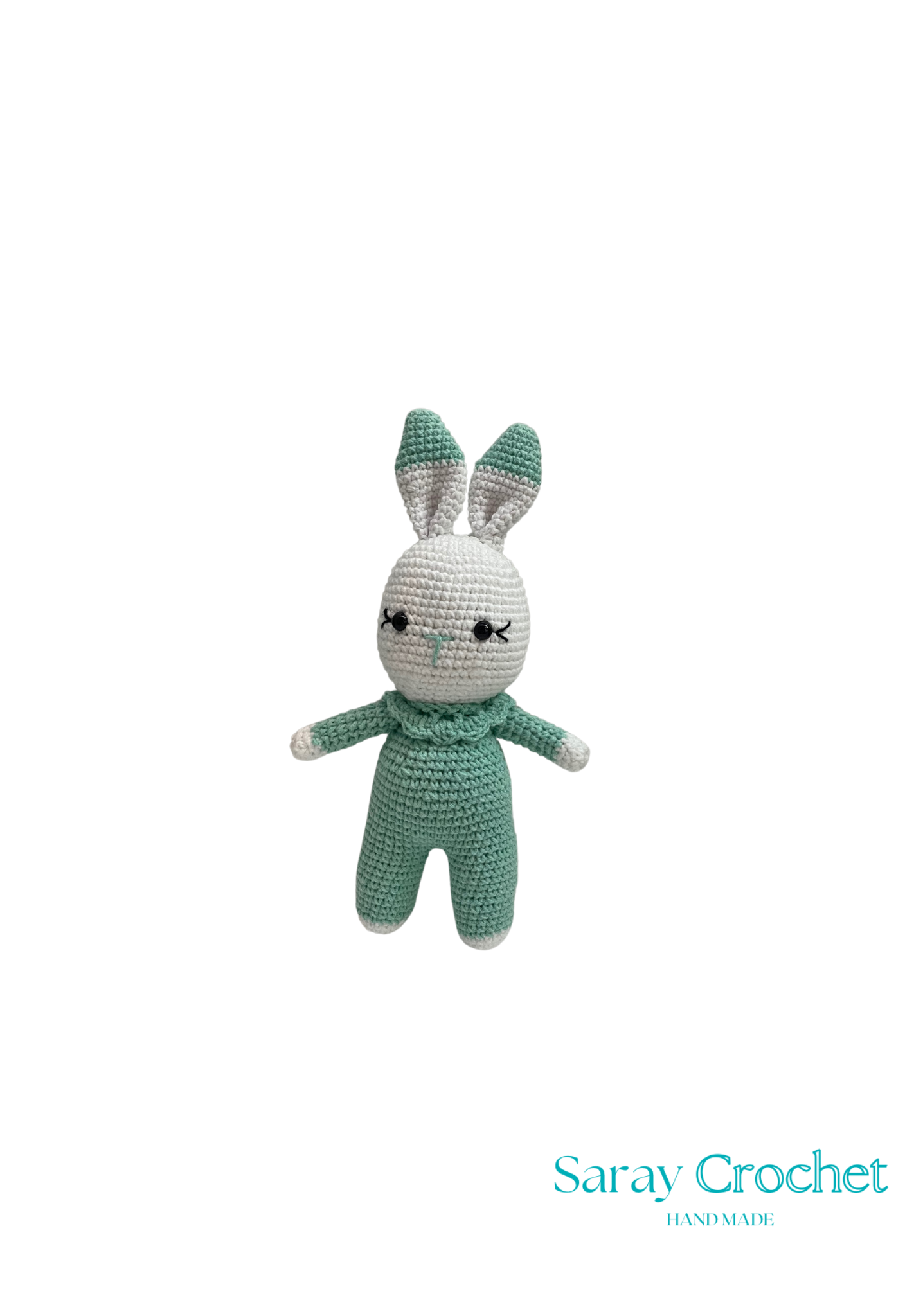 Crocheted rabbit toy in green outfit on white background