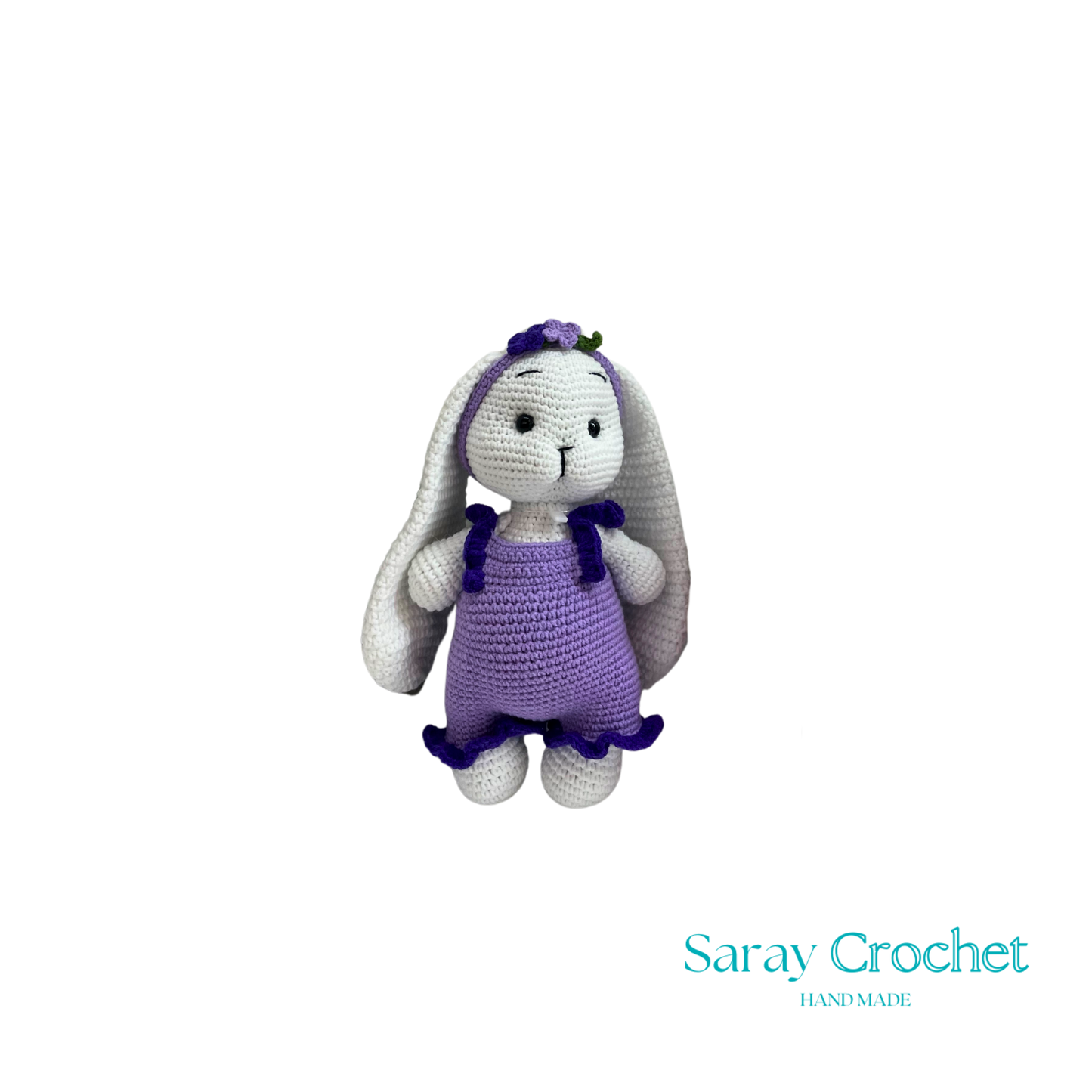 Crocheted bunny toy with purple dress on white background