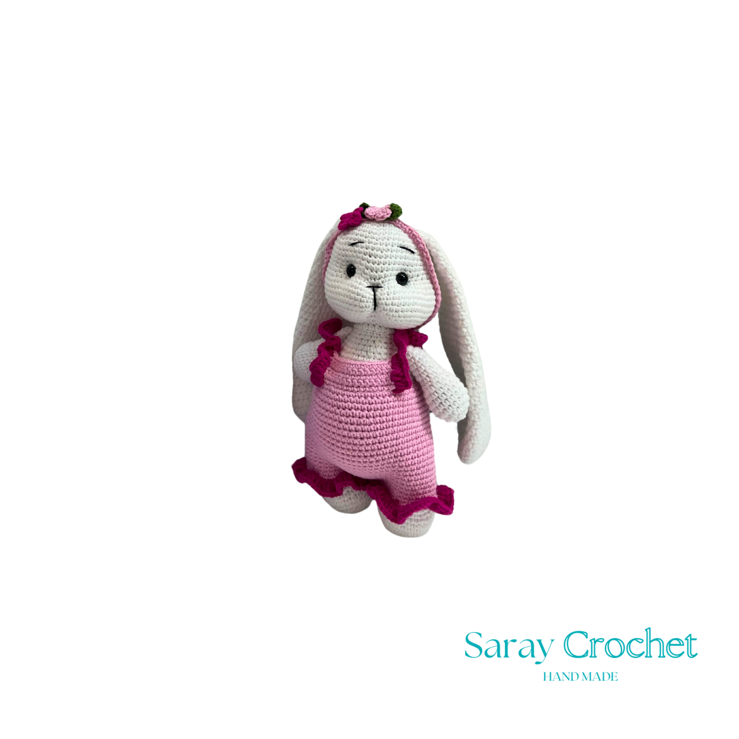Crocheted bunny toy with pink dress on white background