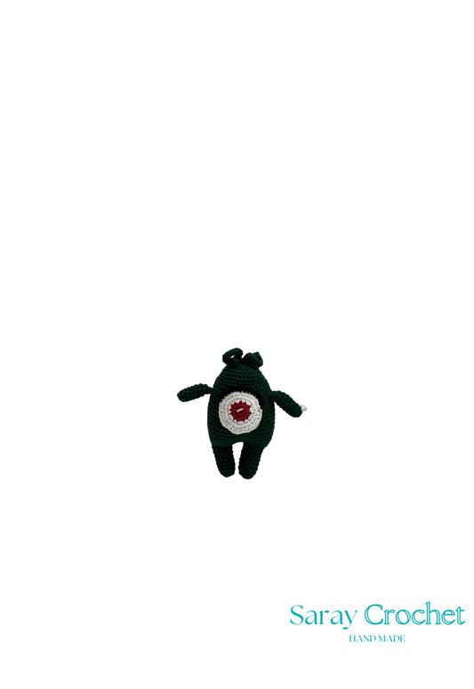 A crochet doll with a black hat and a red and white pattern on its body, positioned against a white background with the text 'Saray Crochet' on the bottom right.