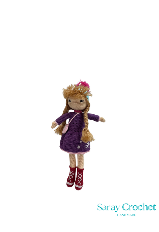 Handmade doll with a pink dress and matching boots, with a snowy background.