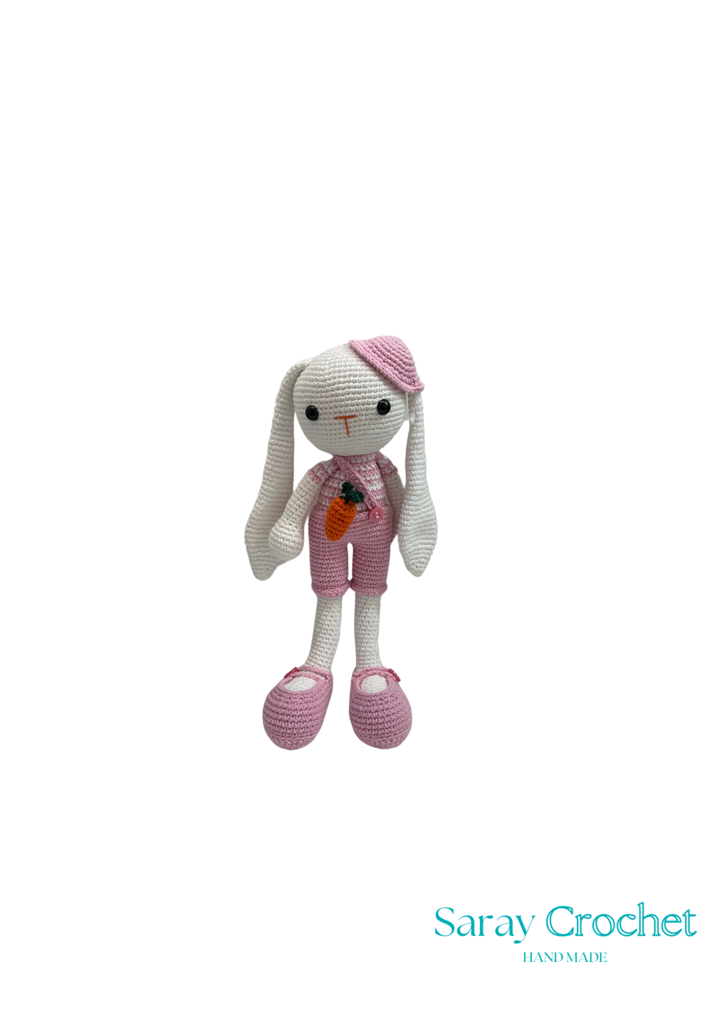 A crochet doll with a pink dress, white hat, and shoes, standing against a white background.