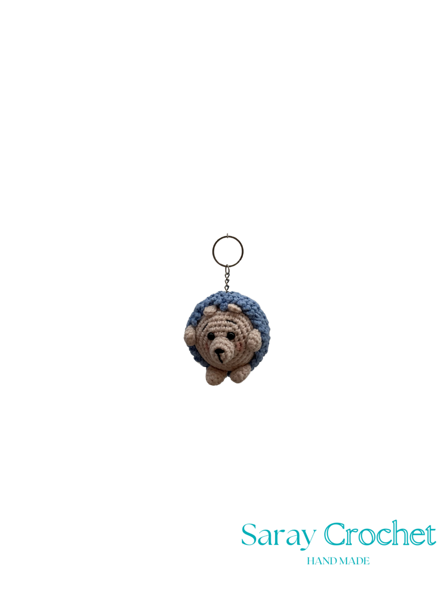 Crocheted bear keychain with blue hood on a white background, branded 'Saray Crochet'.