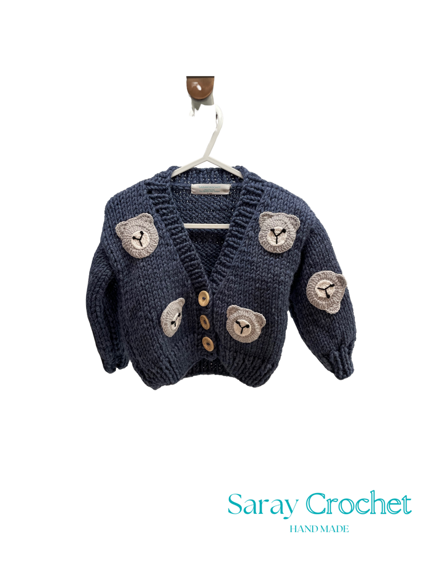 Knitted cardigan with bear designs on a hanger, branded 'Saray Crochet'.