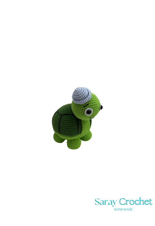 Crochet turtle wearing a green hat