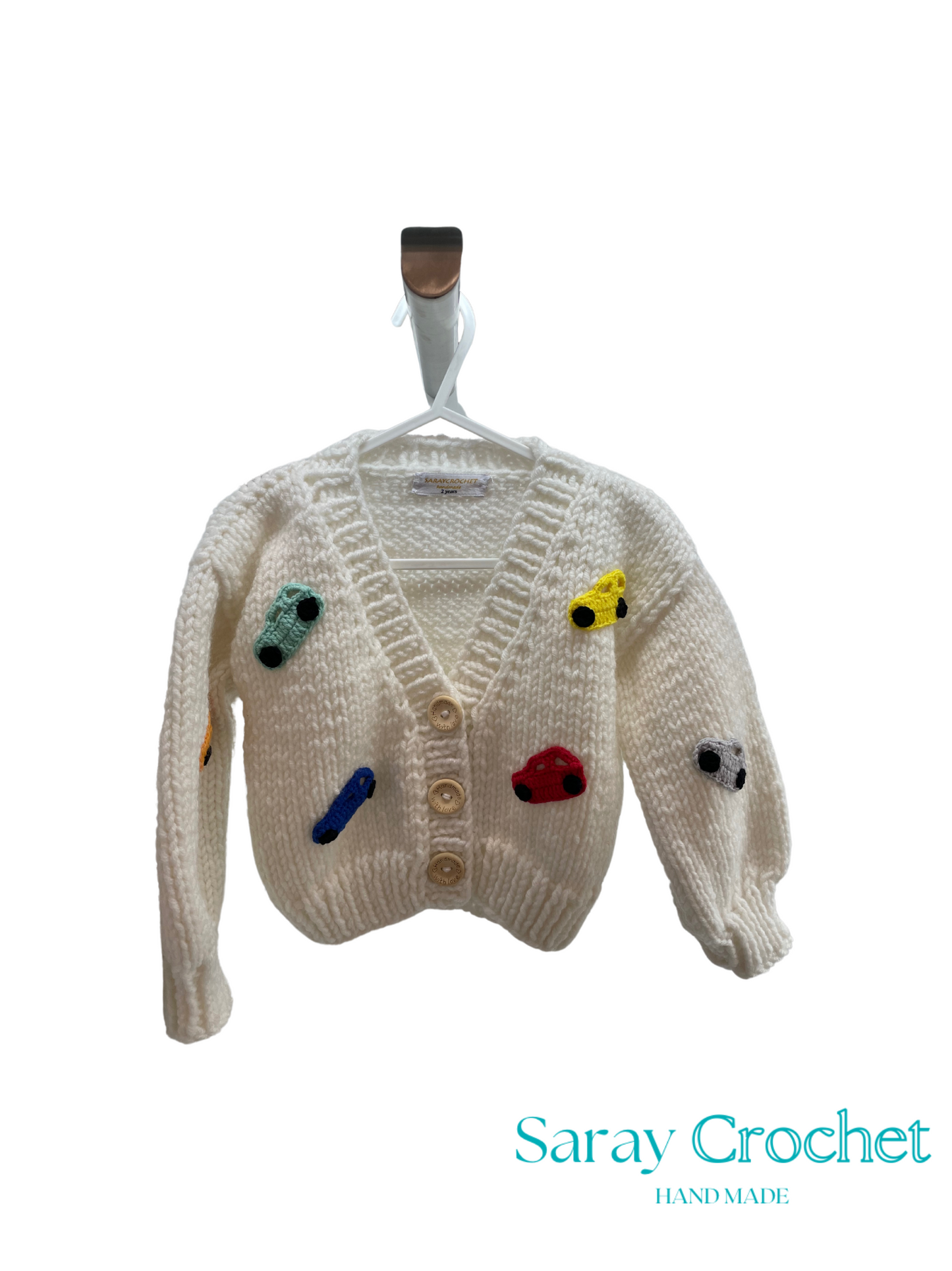 Knitted cardigan with colorful buttons on a hanger, branded 'Saray Crochet'.