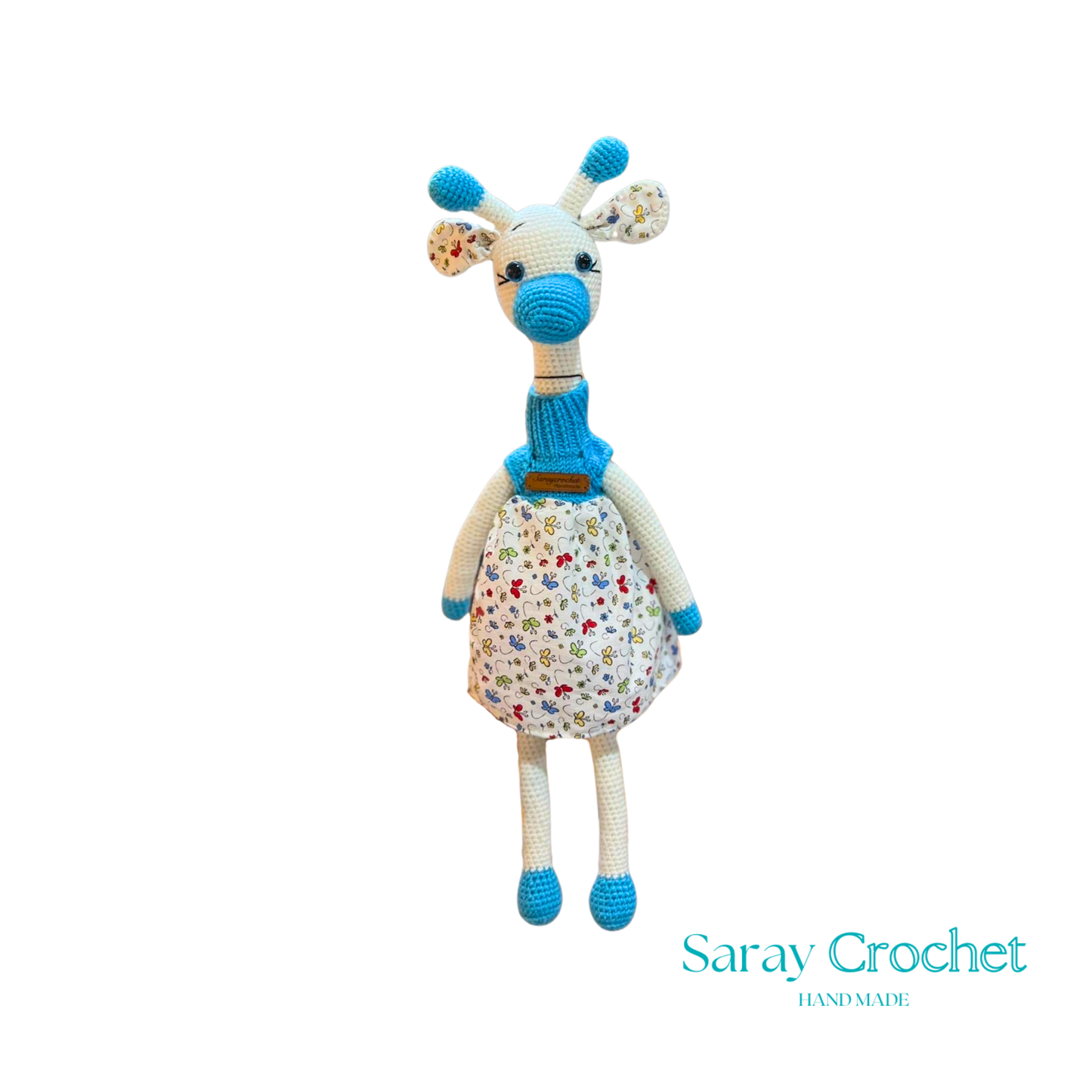 Handmade plush giraffe toy with a floral dress and blue accents, equipped with a pacifier.
