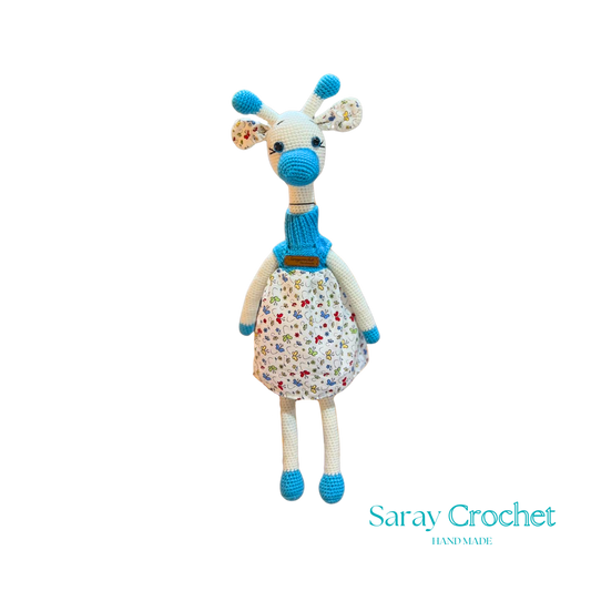 Handmade plush giraffe toy with a floral dress and blue accents, equipped with a pacifier.