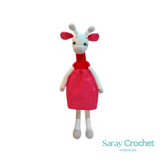 Handmade plush giraffe toy with a red dress and white body, standing upright.
