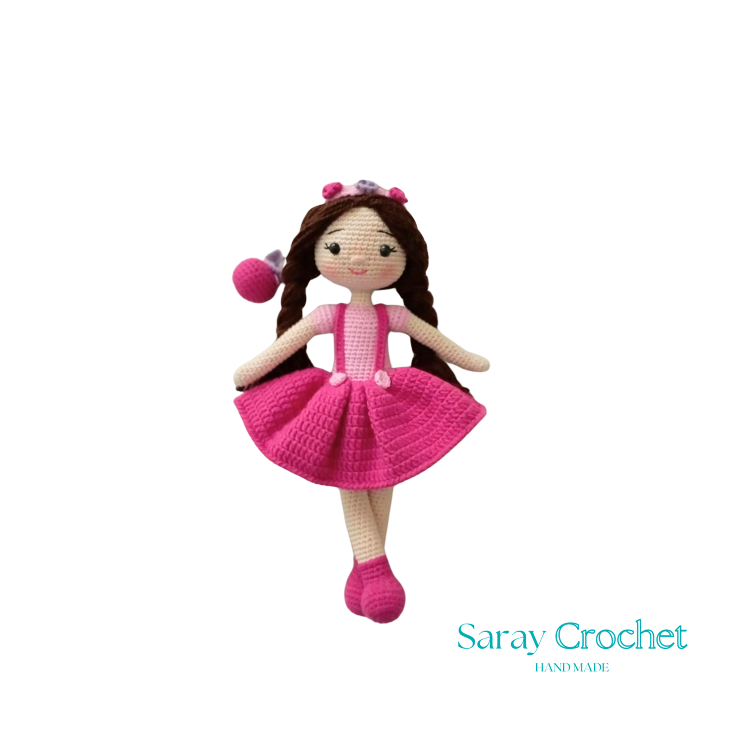 A handcrafted doll with a pink and white outfit, featuring a floral headband and matching shoes.