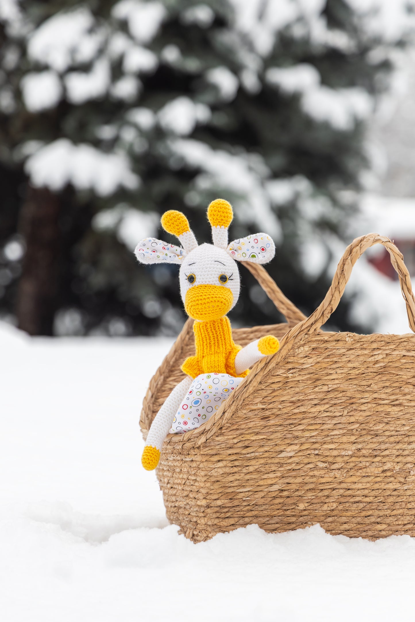 Igračka žirafica sa žutom haljinicom i korpicom u snijegu