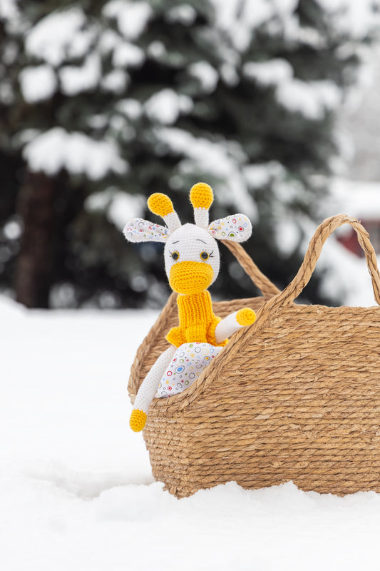 Igračka žirafica sa žutom haljinicom i korpicom u snijegu