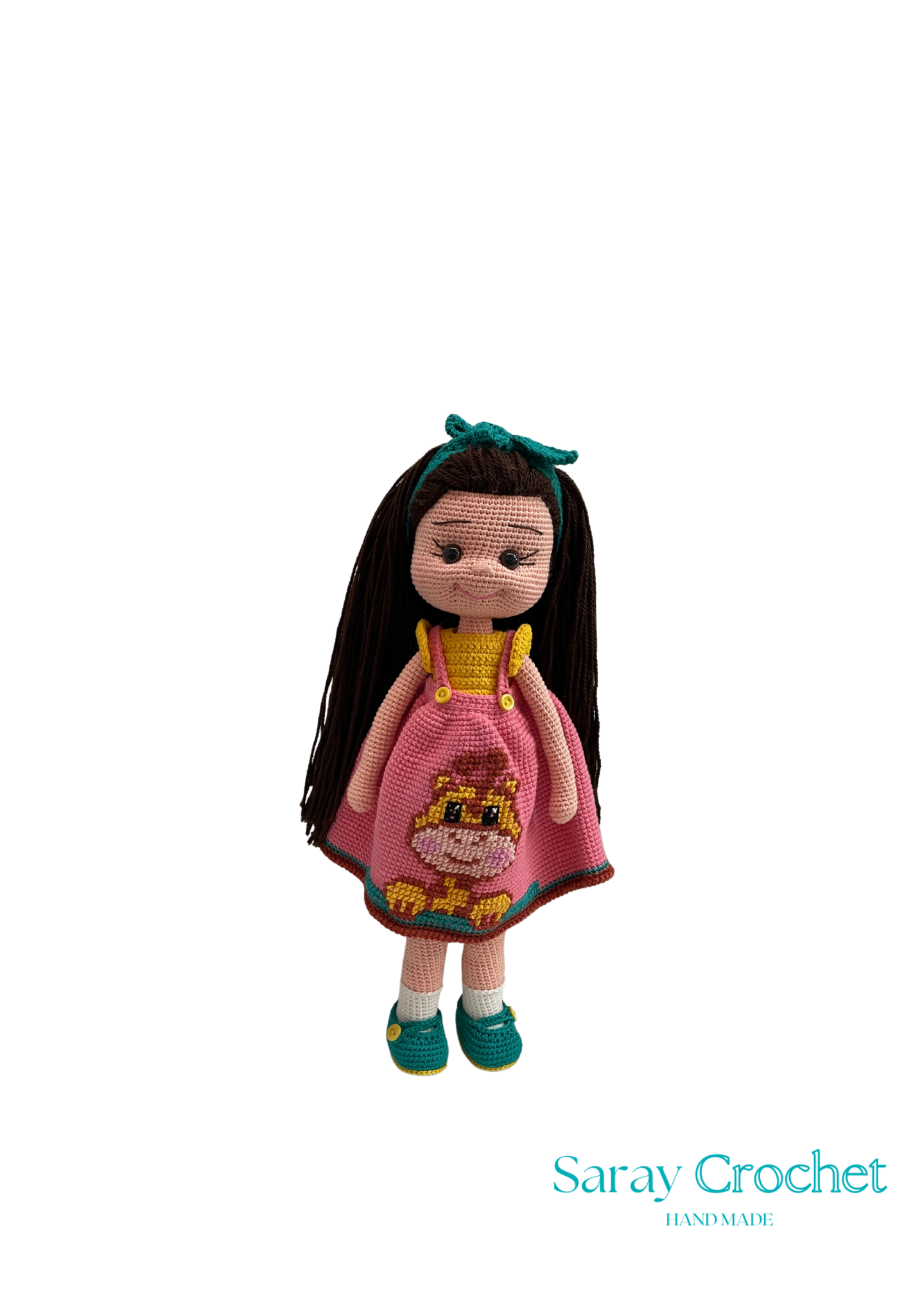 Handmade doll with pink dress and long dark hair on a white background, branded 'Saray Crochet'.