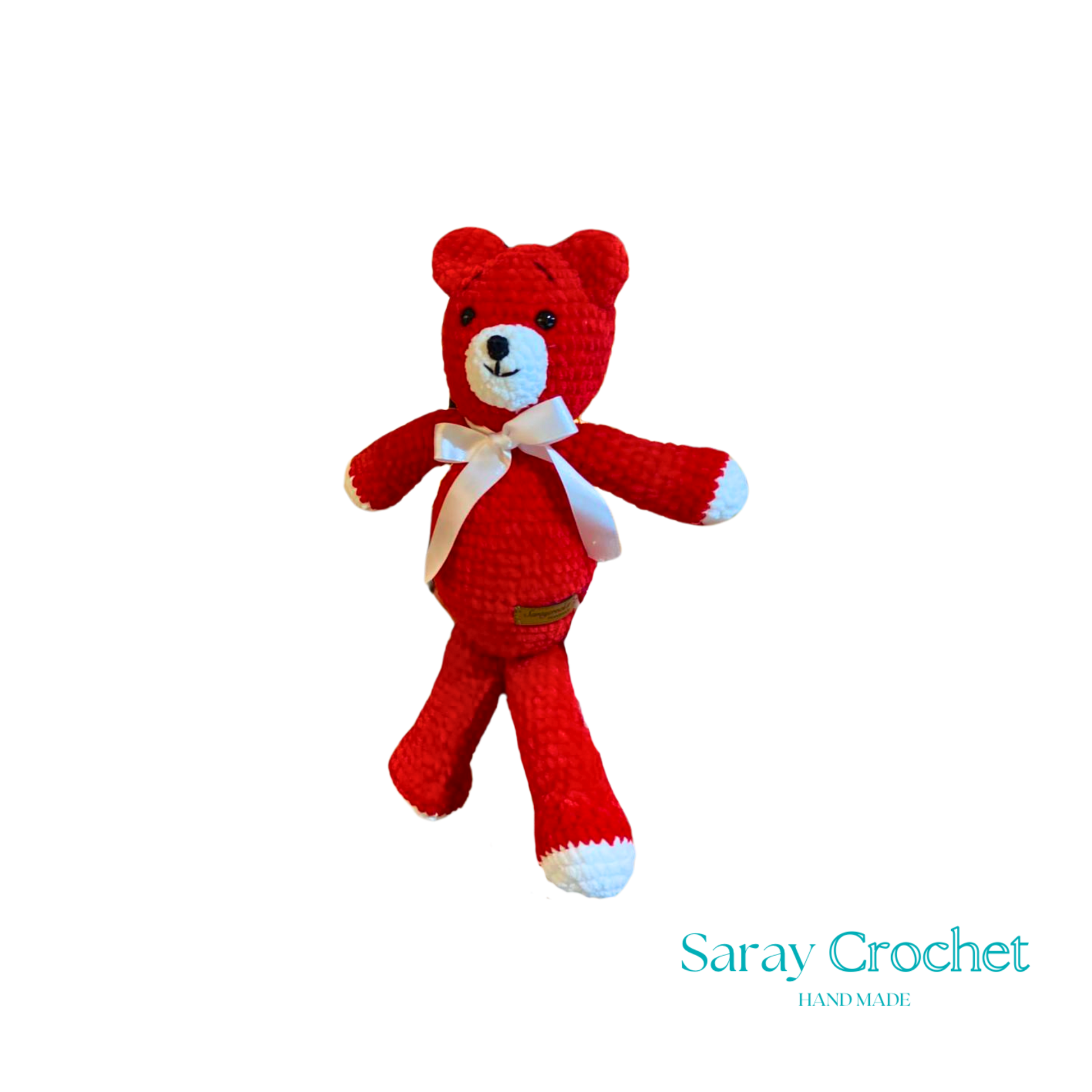 A red plush toy in the shape of a bear with a white bow ribbon around its neck.