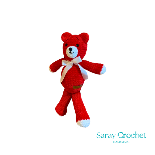 A red plush toy in the shape of a bear with a white bow ribbon around its neck.