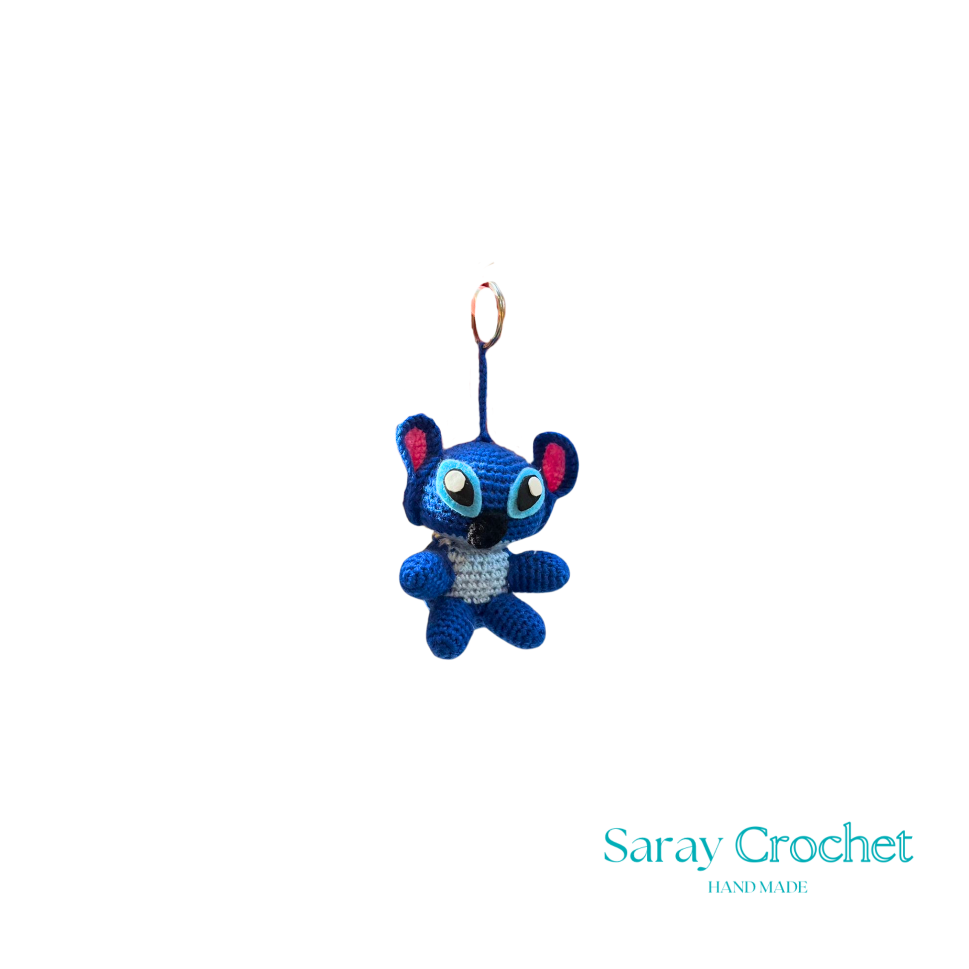 A blue character keychain with a design resembling a stitch from a fabric or crochet pattern.