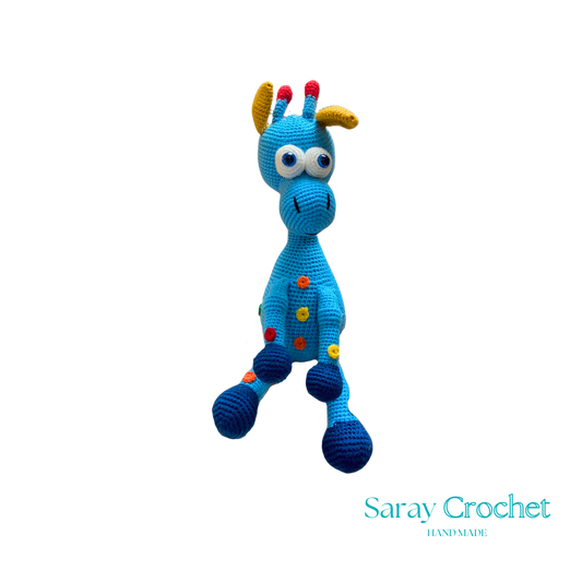A handcrafted blue and pink giraffe toy with patterned details, standing upright.