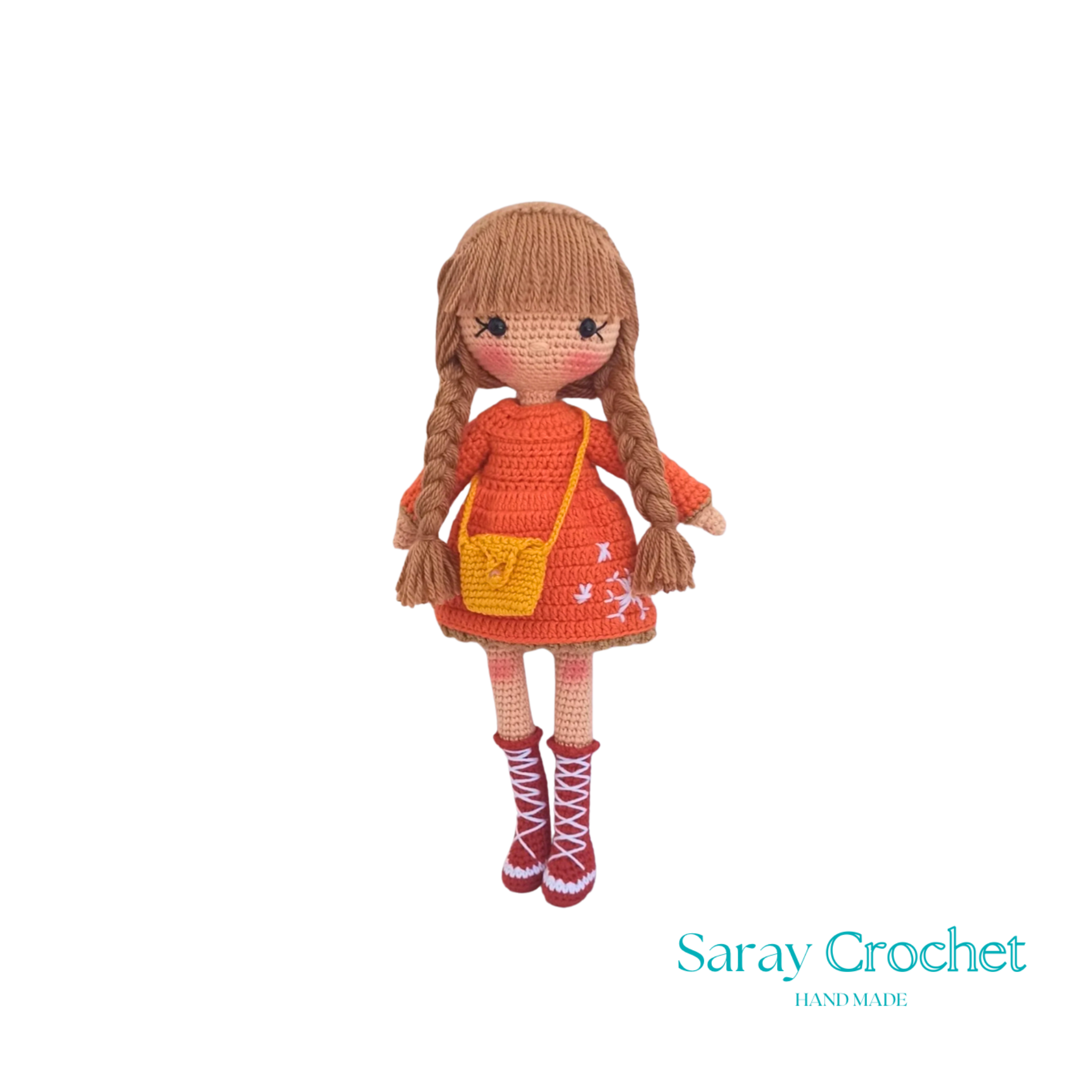 Handmade crocheted doll with orange winter coat and scarf, beige boots, and brown hair.
