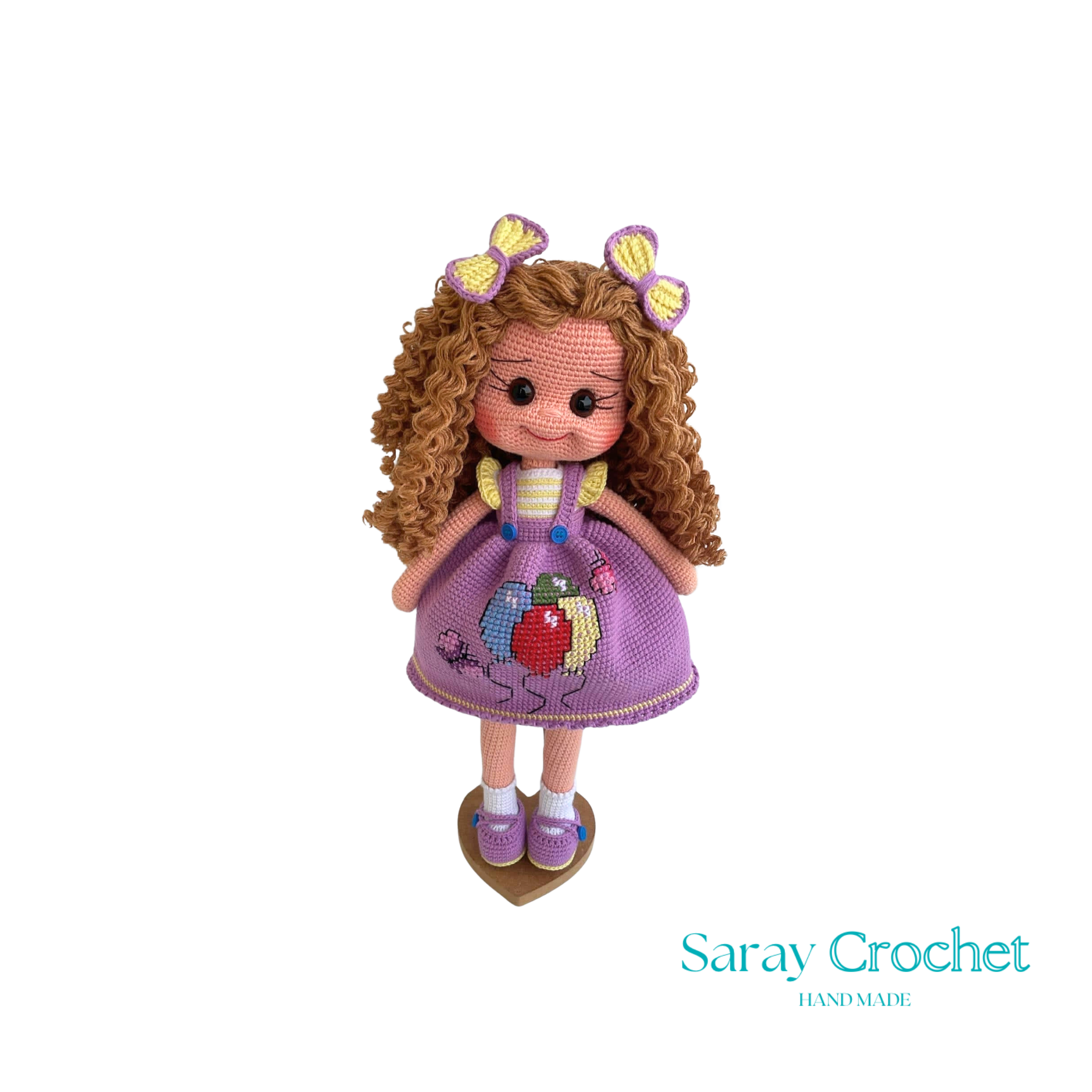 Handmade doll with curly brown hair and a purple dress with balloon print, complete with a bow and lace details.