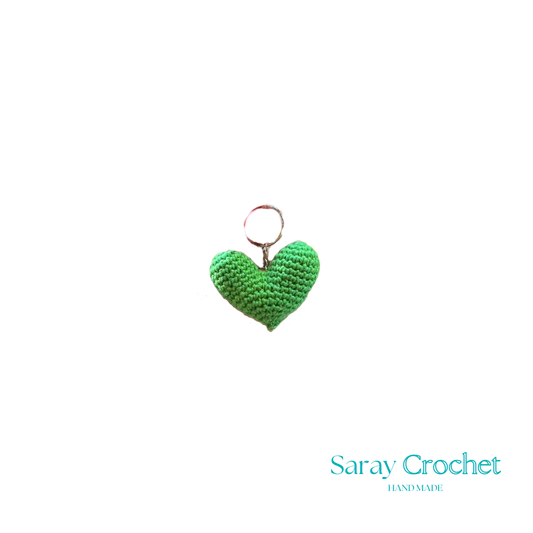 Green crochet heart keychain on a white background with 'Saray Crochet' branding.