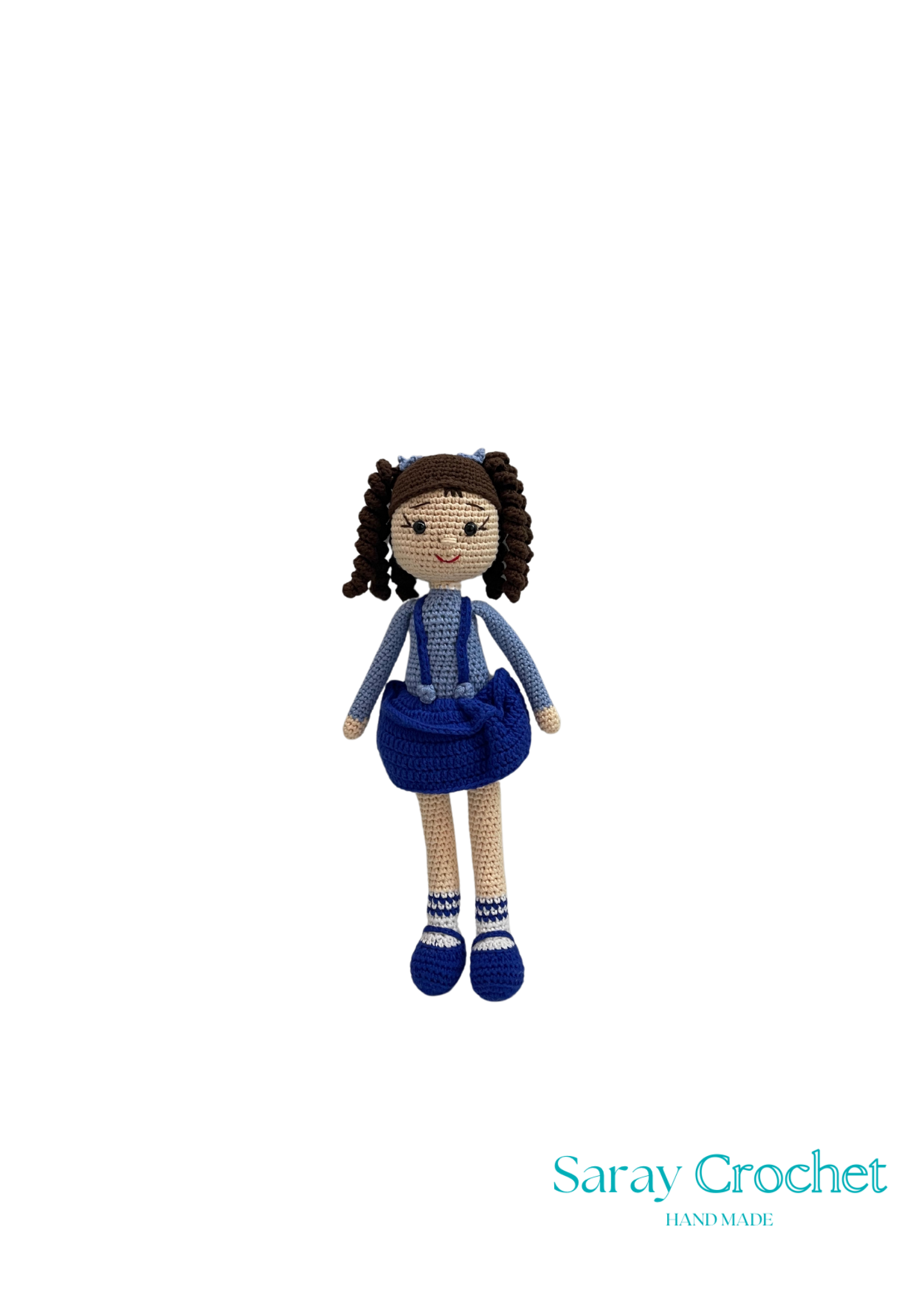Handmade doll with blue dress and brown hair on a white background, branded 'Saray Crochet'.