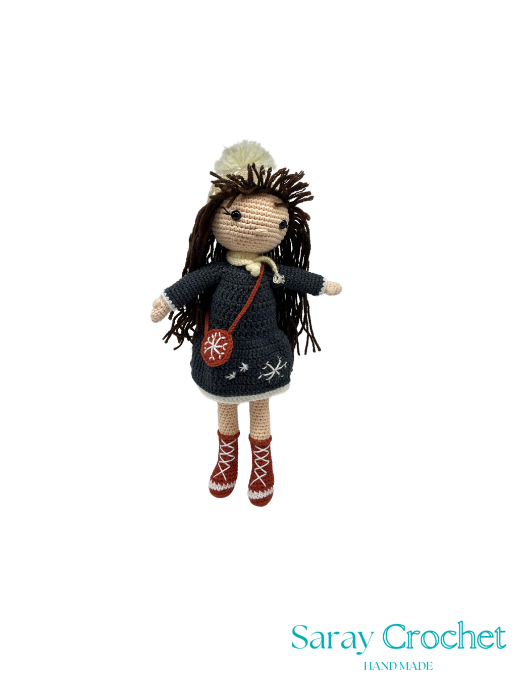 Crocheted doll with dark hair and outfit on a white background, branded 'Saray Crochet'.