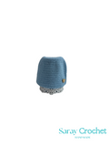Blue crocheted hat with a white polka dot band on a white background, branded 'Saray Crochet'.
