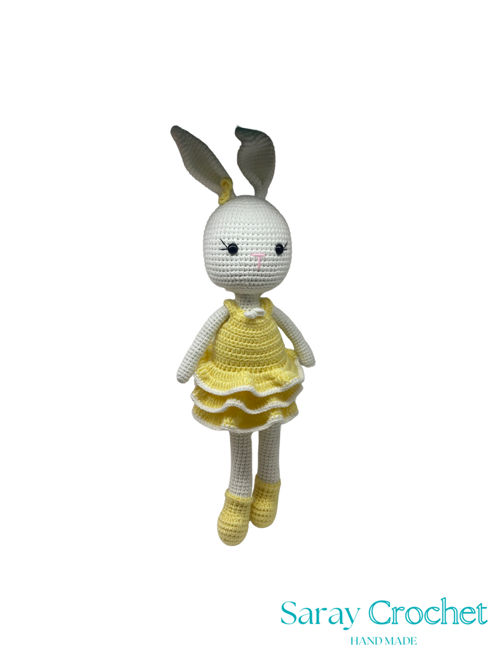 Crocheted bunny toy with a yellow dress on a white background, branded 'Saray Crochet'.
