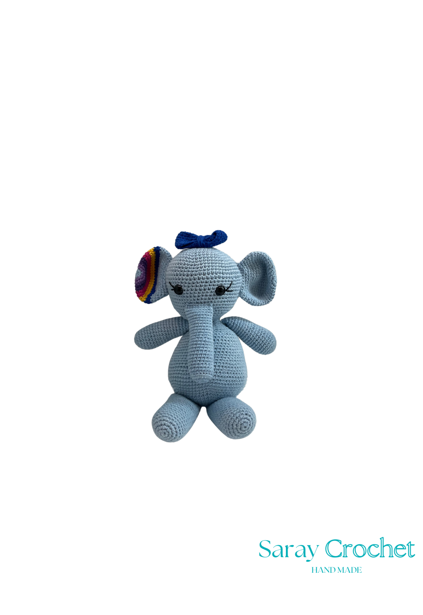Crocheted blue elephant toy with a rainbow bow on a white background.