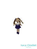 Crocheted doll with braided hair on a white background, branded 'Saray Crochet'.