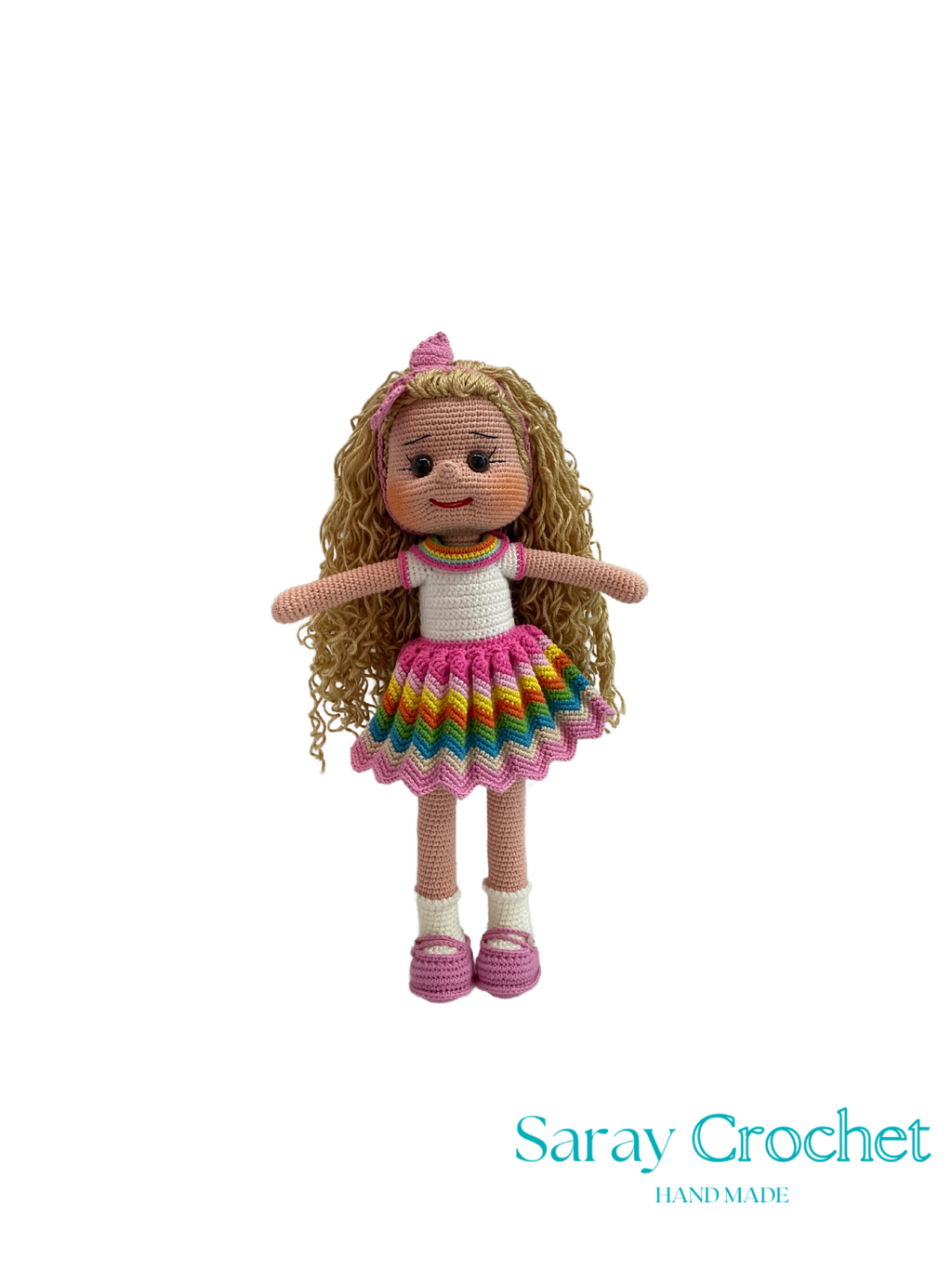 Crocheted doll with a rainbow skirt on a white background, branded 'Saray Crochet'.
