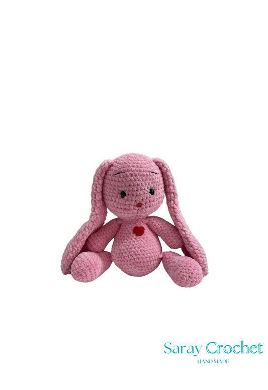Pink crochet bunny toy on a white background