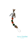 Crocheted bunny charm with colorful beads on a white background, branded 'Saray Crochet'.
