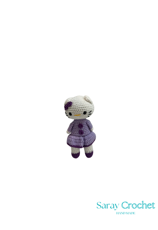 Crocheted toy with a purple outfit on a white background, branded 'Saray Crochet'.