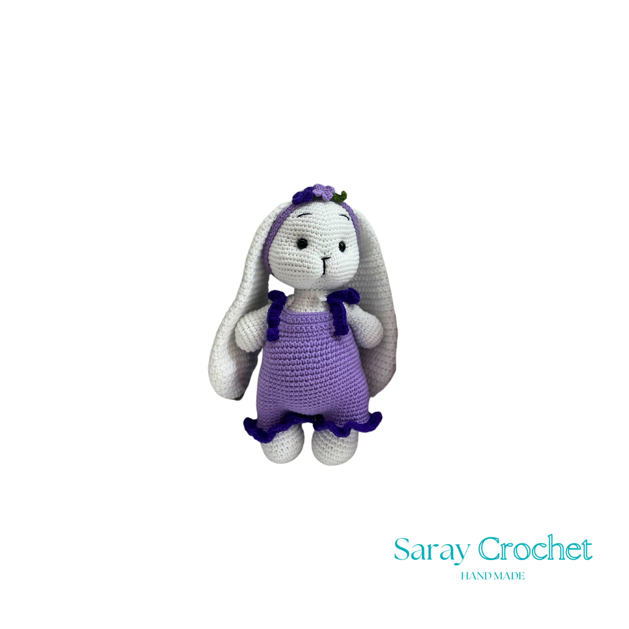 Crocheted bunny toy with purple dress on white background