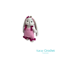 Crocheted bunny toy with pink dress on white background