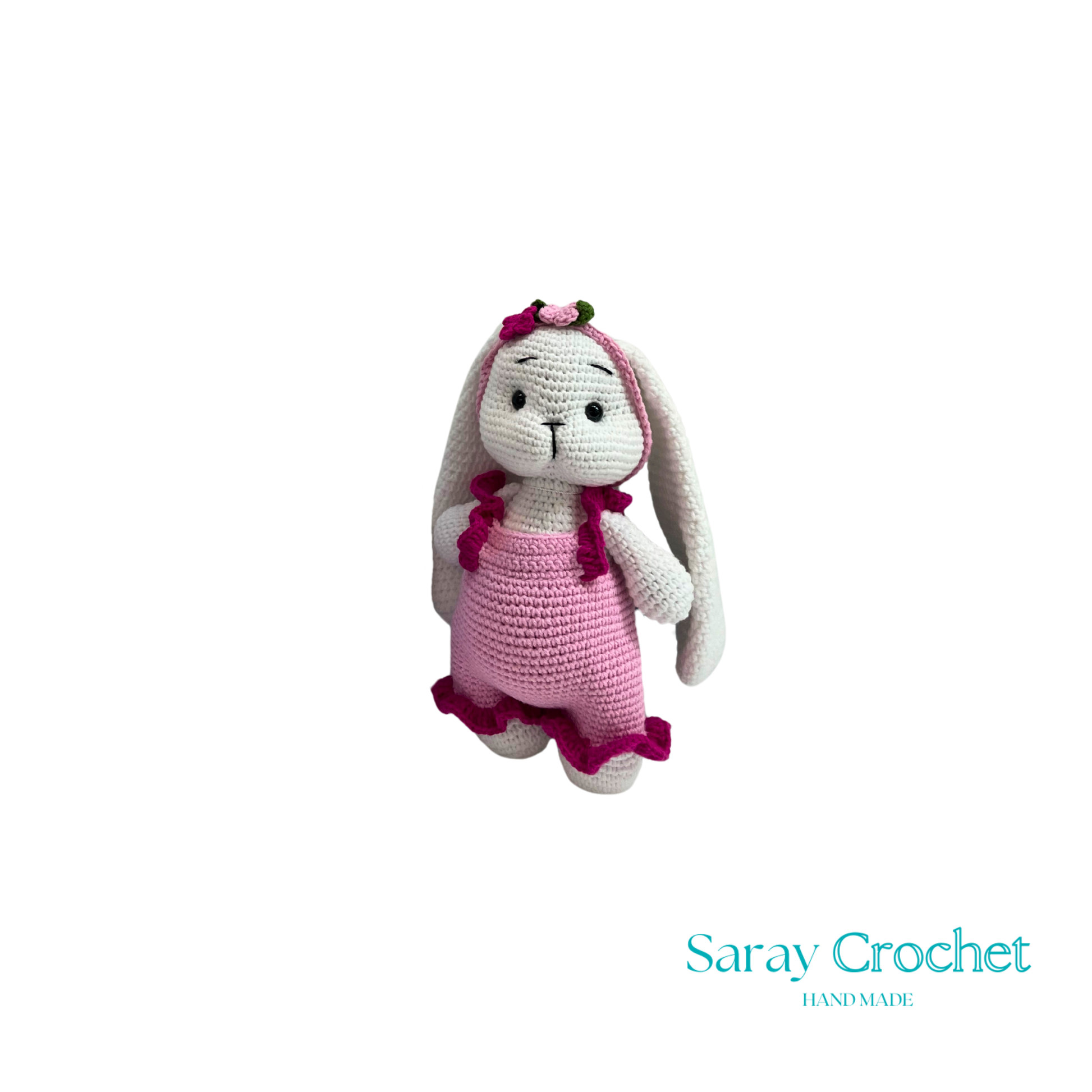 Crocheted bunny toy with pink dress on white background