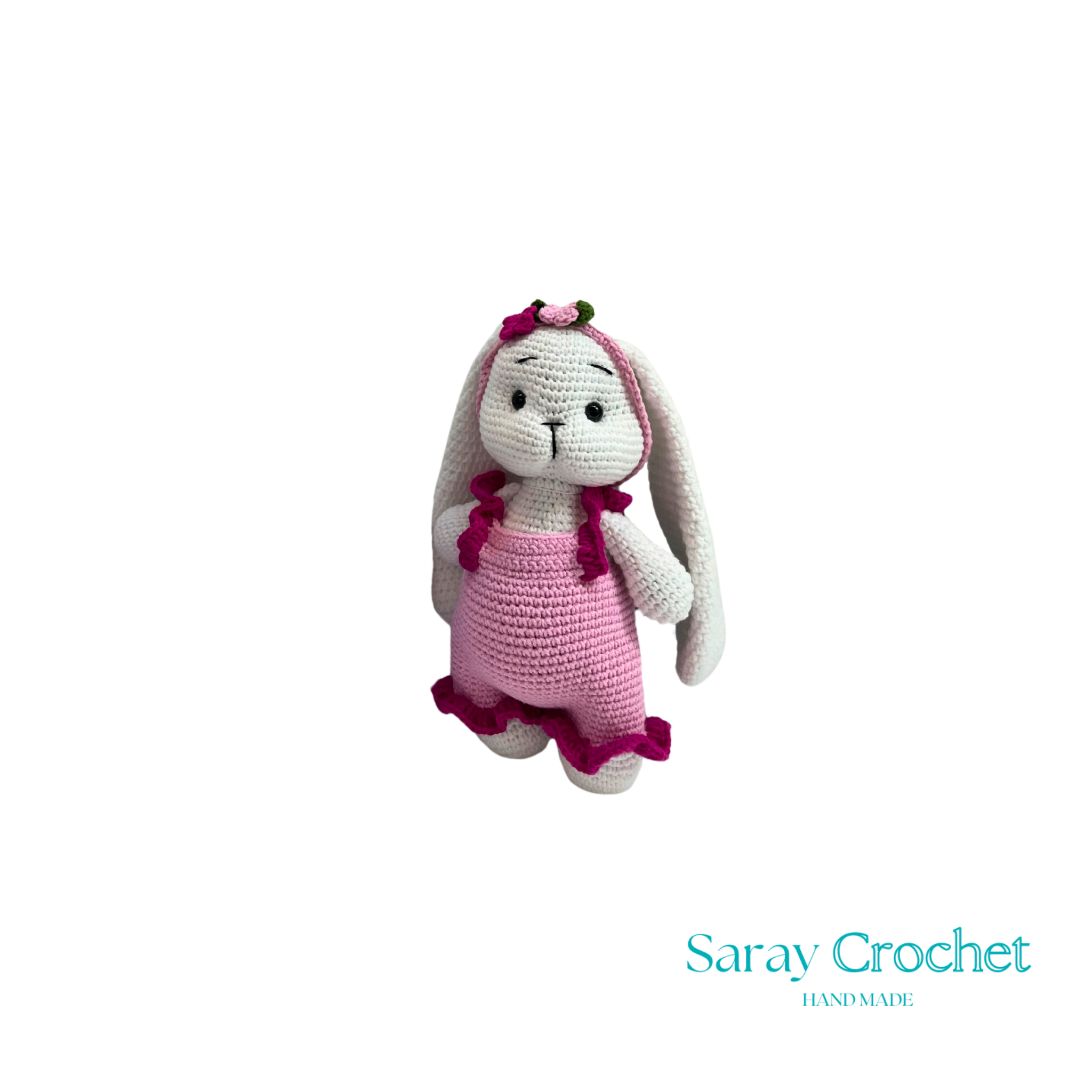 Crocheted bunny toy with pink dress on white background