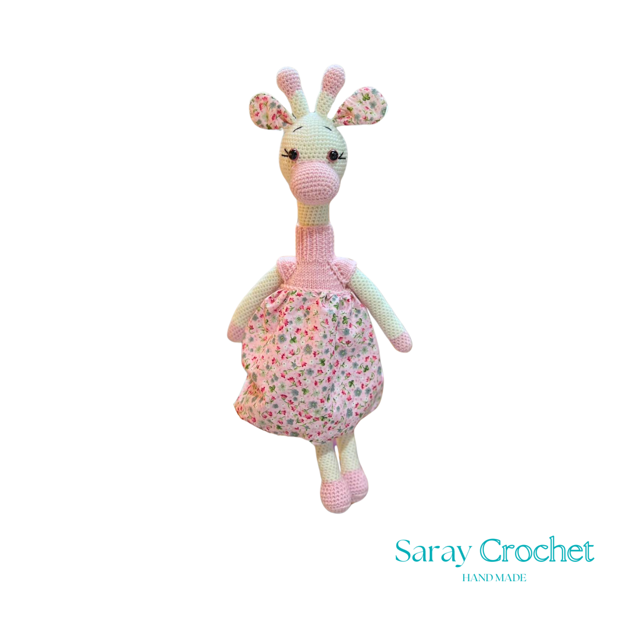 Handmade plush giraffe toy with a pink floral dress and white accents, part of the SarayCrochet collection.