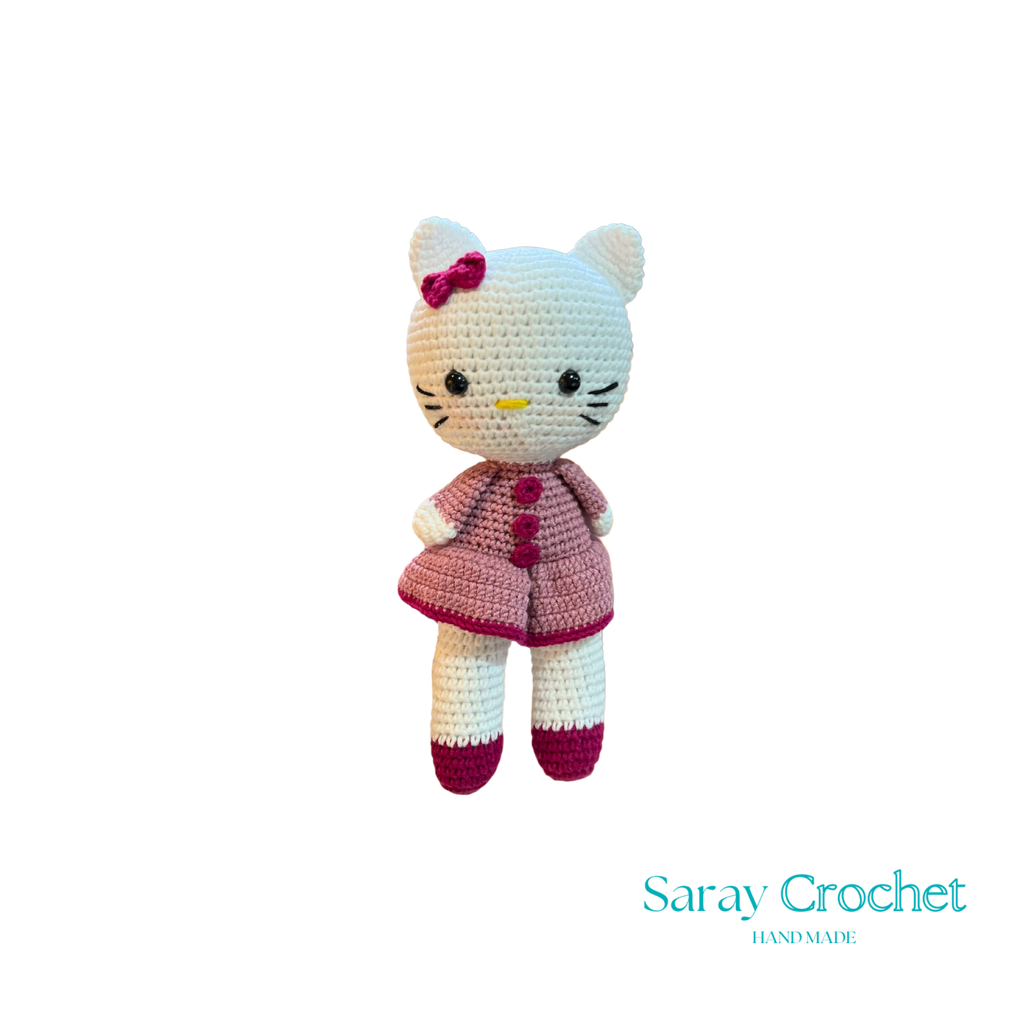Crocheted cat toy with a pink dress on a white background, branded 'Saray Crochet'.