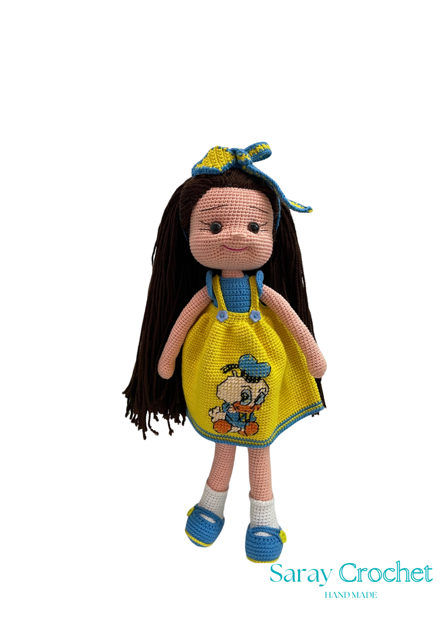 Handmade doll with a golden-yellow dress featuring a character, long black hair, and a blue bow on its head.
