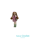 Crocheted doll with braided hair and a pink dress on a white background, branded 'Saray Crochet'.